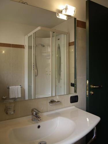 a bathroom with a sink and a large mirror at Grande Albergo Maugeri in Acireale