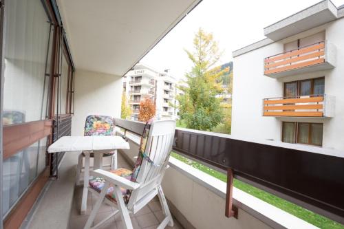 a balcony with two chairs and a table on it at Haus Fortuna in Leukerbad