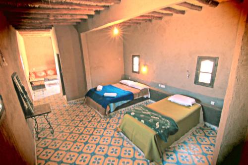 a room with two beds and a staircase at Maison Adrar Merzouga in Merzouga