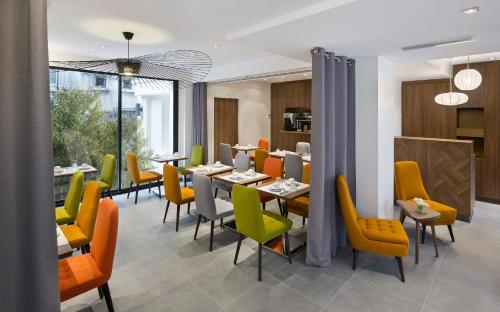 un comedor con mesas y sillas amarillas en Best Western Plus 61 Paris Nation Hotel, en París