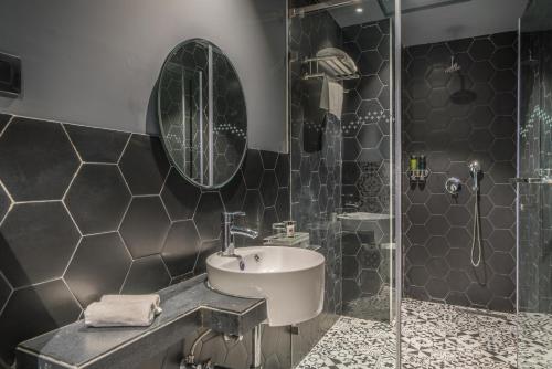 ein Bad mit einem Waschbecken und einer Dusche in der Unterkunft Hotel B plus L in Hyderabad