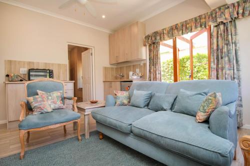 a living room with a blue couch and two chairs at The Annexe at No. 5 in Montagu