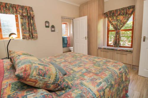 a bedroom with a bed and a lamp and windows at The Annexe at No. 5 in Montagu