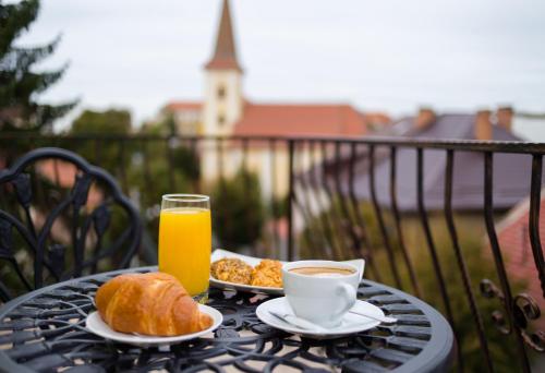 a table with a breakfast of coffee and croissants and orange juice at Style Residence in Sibiu