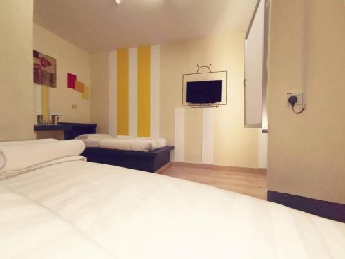 a bedroom with a bed and a tv on the wall at Abby by the river in Ipoh