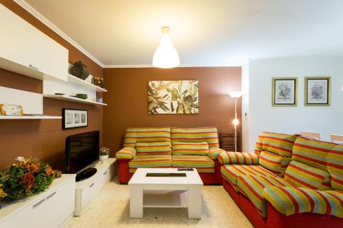 un soggiorno con divano e TV di Holi-Rent Albareda a Siviglia