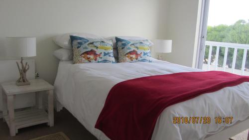 a bedroom with a bed and a window at The Tides 7 in Struisbaai