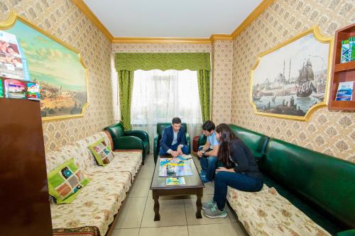 a man and a woman sitting on a couch in a living room at Meddusa Hotel in Istanbul