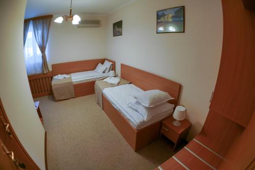 a small room with two beds and a window at Bucharest Downtown Inn in Bucharest