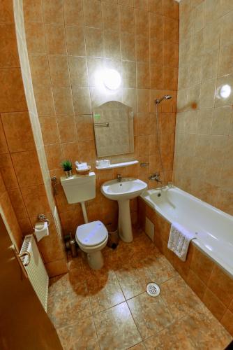 a bathroom with a toilet and a sink and a tub at Bucharest Downtown Inn in Bucharest