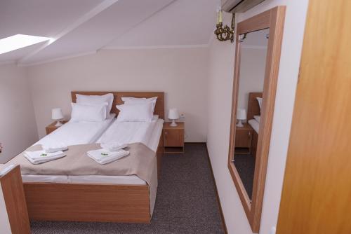 una camera con letto e specchio di Bucharest Downtown Inn a Bucarest