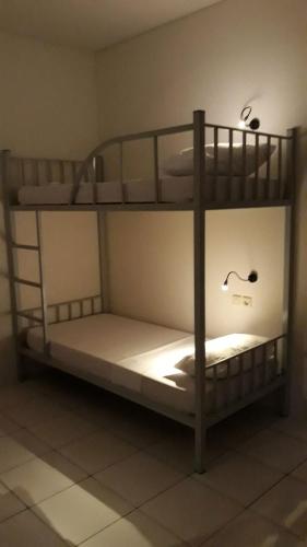 two bunk beds in a room with a light at Bujang Lapuk Hostel in Sekotong