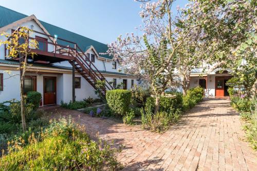 a white house with a brick driveway at Malagas Hotel in Malgas