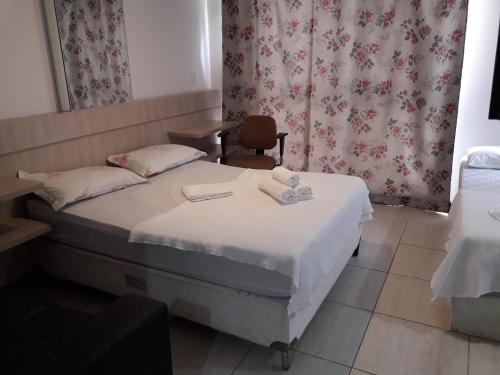 a bedroom with a bed with two towels on it at Mar do Cabo Branco Residence in João Pessoa