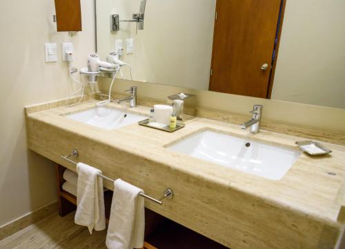 ein Badezimmer mit zwei Waschbecken und einem großen Spiegel in der Unterkunft Krystal Urban Cancun & Beach Club in Cancún