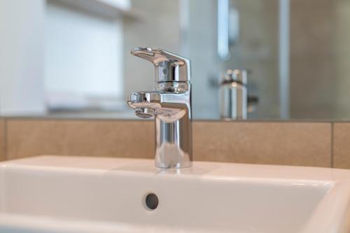a bathroom sink with a chrome faucet at HARBR. hotel Konstanz in Konstanz