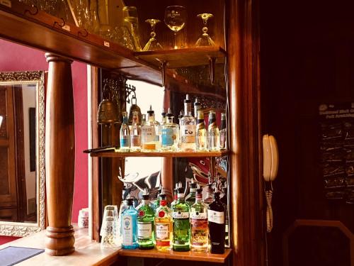a shelf filled with lots of bottles of alcohol at Purbeck House Hotel & Louisa Lodge in Swanage