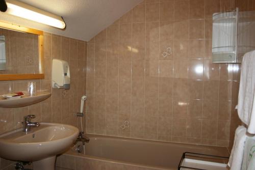 a bathroom with a sink and a bath tub and a sink at Hotel Le Chamois Logis in Molines-en-Queyras