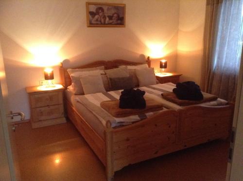 sypialnia z dużym drewnianym łóżkiem z 2 lampami w obiekcie Ferienwohnung Christine w mieście Tanzfleck