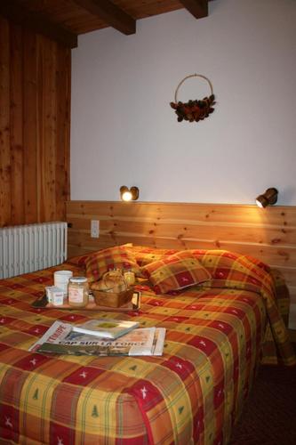 a bedroom with a bed with a checkered blanket at Hotel Le Chamois Logis in Molines-en-Queyras
