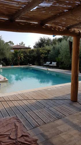 une grande piscine avec une terrasse en bois dans l'établissement 1262 Chemin des Pignatelles, à La Motte