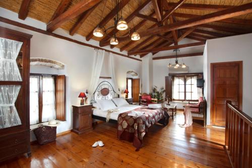 ein großes Schlafzimmer mit einem Bett und einem Tisch in der Unterkunft Pietra Suite in Monemvasia