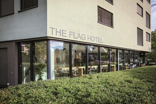 a large building with a sign that reads the flag hotel at THE FLAG Zürich in Zürich