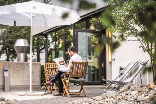 a man sitting in a chair reading a newspaper at THE FLAG Zürich in Zürich