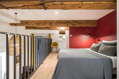 um quarto com uma cama e uma parede vermelha em Honorê - Suite Vaubecour em Lyon