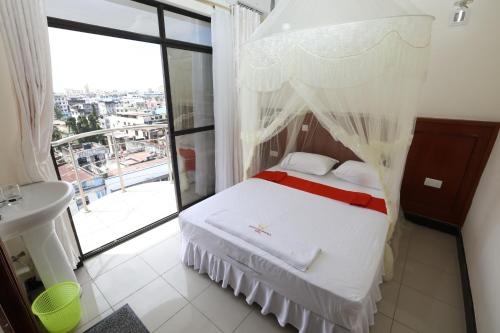 a bedroom with a bed and a large window at Sheratton Regency Hotel in Mombasa