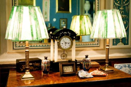 a table with two lamps and a clock on it at Zámek Jemniště in Postupice
