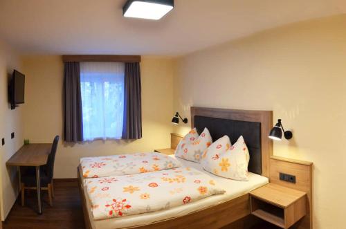 a bedroom with a bed and a desk and a window at Die Reinbachstube in Sankt Johann im Pongau