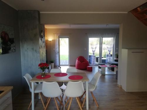 a kitchen and living room with a table and chairs at Dofu Domek in Trzęsacz