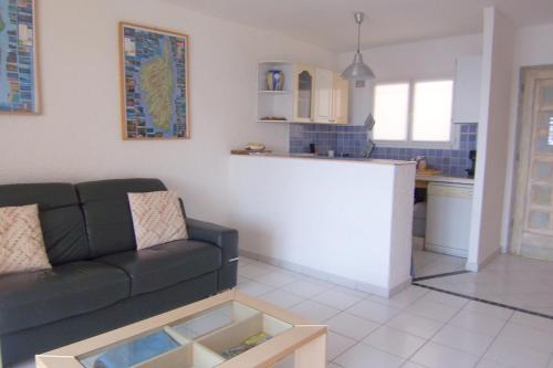 un salon avec un canapé et une cuisine dans l'établissement YVETTE, à Tarcu