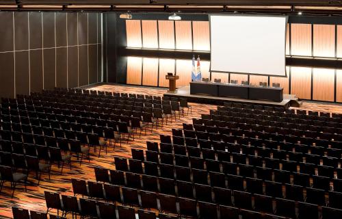 an empty lecture hall with a podium and a screen at Hotel Pullman City Center Rosario in Rosario