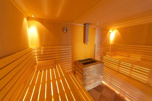a large empty sauna with a brick boiler and lights at JUFA Hotel Weinviertel - Eselsmühle in Seefeld-Kadolz