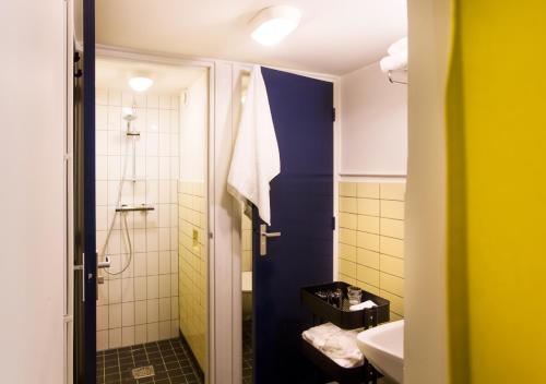 een kleine badkamer met een douche en een wastafel bij SWEETS - Gerben Wagenaarbrug in Amsterdam
