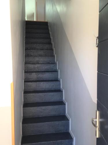 a staircase in a house with black carpet at Le T2 moderne des Palmiers au coeur de Moissac in Moissac