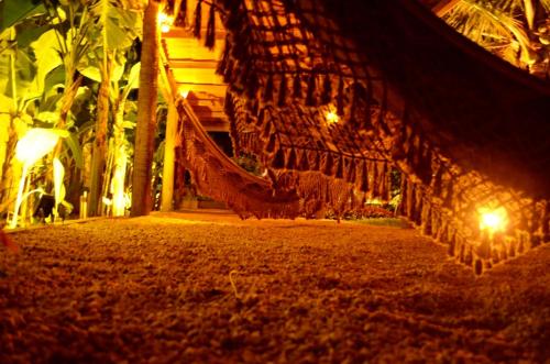 a hammock in a resort at night with lights at Pousada Cristal da Terra in Sao Jorge