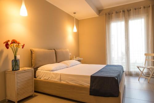 a bedroom with a bed and a vase of flowers on a night stand at Casa del Riccio in Mazzeo