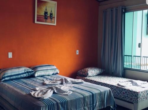 a bedroom with a bed with towels on it at Flat do Léo in Praia de Araçatiba