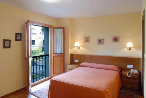 a bedroom with a bed and a large window at Hotel Restaurante El Manquin in Villaviciosa