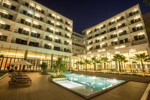 a large building with a swimming pool in front of it at Paragon Grand Resort in Jomtien Beach