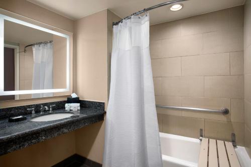 a bathroom with a shower curtain and a sink at Crowne Plaza Hotel Los Angeles Harbor, an IHG Hotel in San Pedro