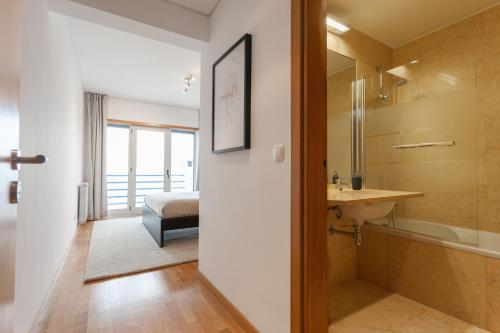 La salle de bains est pourvue d'un lavabo et d'un lit dans la chambre. dans l'établissement The Residences at Oriente II, à Lisbonne