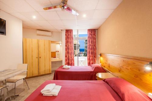 een hotelkamer met 2 bedden en een tafel bij Alborada Apart Hotel in Sliema