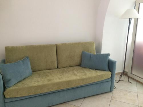 a couch in a room with two blue pillows at casa gramazio in Manfredonia