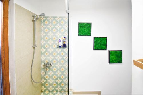 a shower in a bathroom with four pictures on the wall at Andrea Apartments in Cluj-Napoca