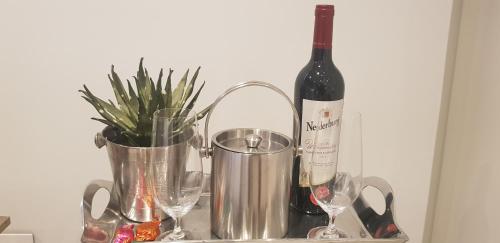 a bottle of wine and two glasses on a shelf at No 2 Heleza Blvd Sibaya, Oceandune, Umhlanga Durban in Umdloti