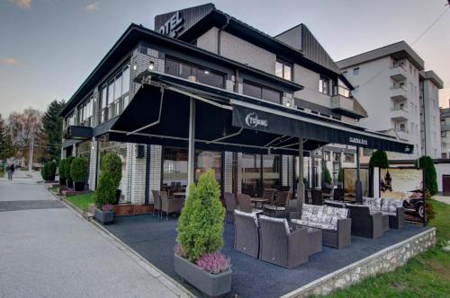 a restaurant with tables and chairs in front of a building at Hotel Zlatna Žita in Pale